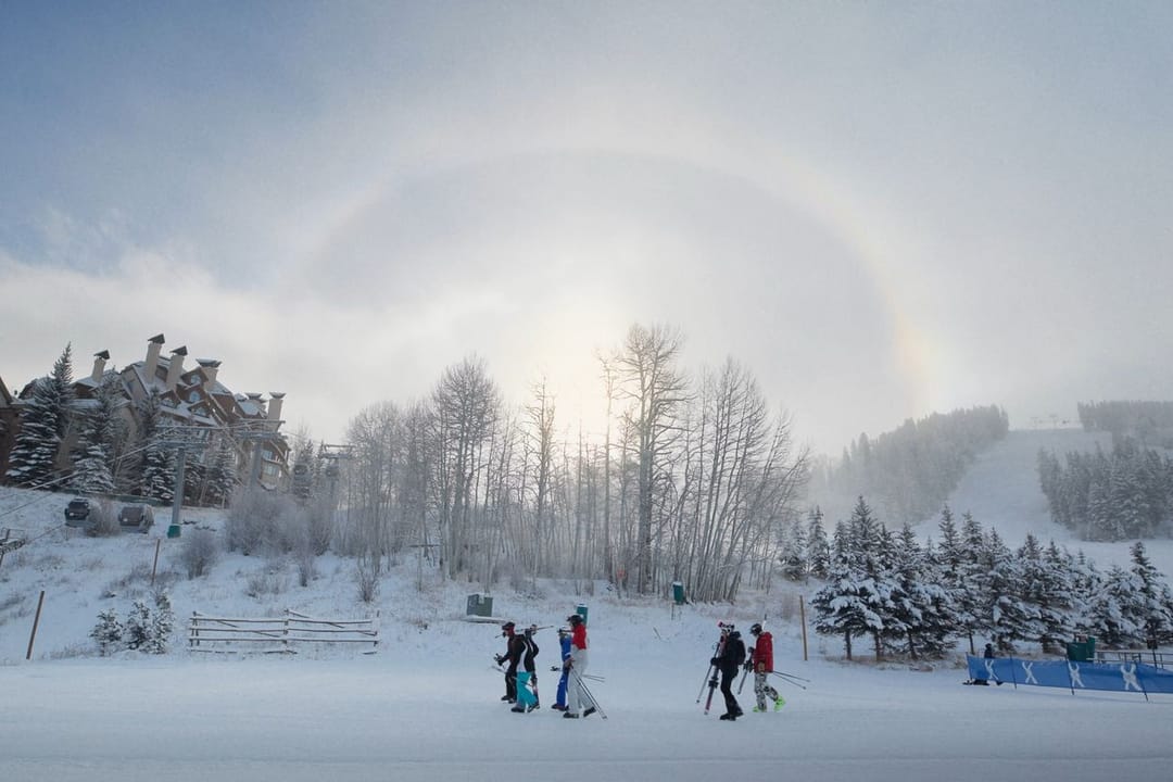 Skiers below a sun halo on a frosty morning at Beaver Creek