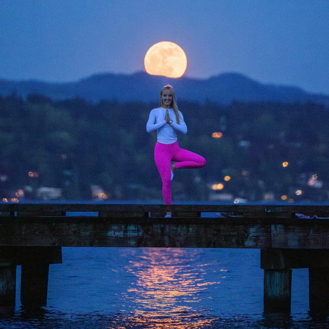 Chelsea Griffin in a yoga pose on a dock under a pink full moon, Madrona Park