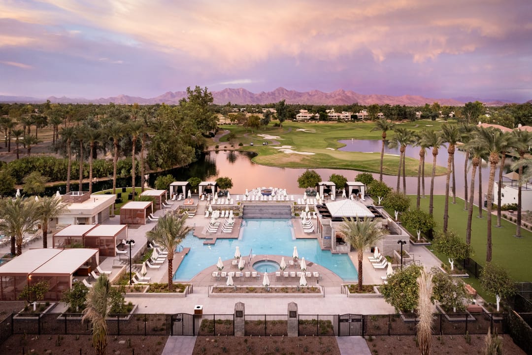 Piscina de Grand Hyatt Scottsdale al atardecer, con el campo de golf y montañas detrás