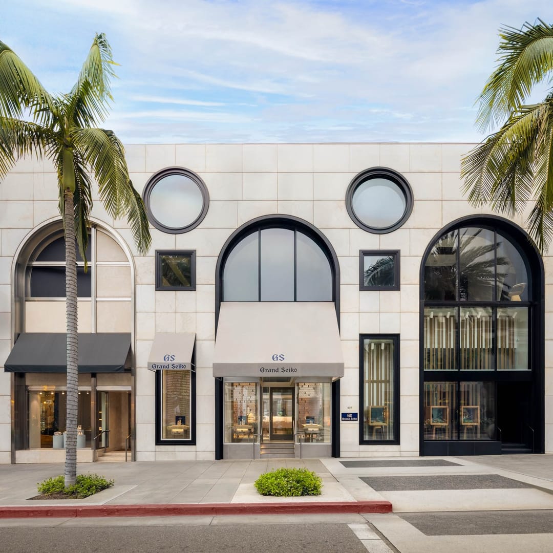 Boutique de Grand Seiko en Rodeo Drive, Beverly Hills, de frente desde la acera opuesta, entre dos palmeras