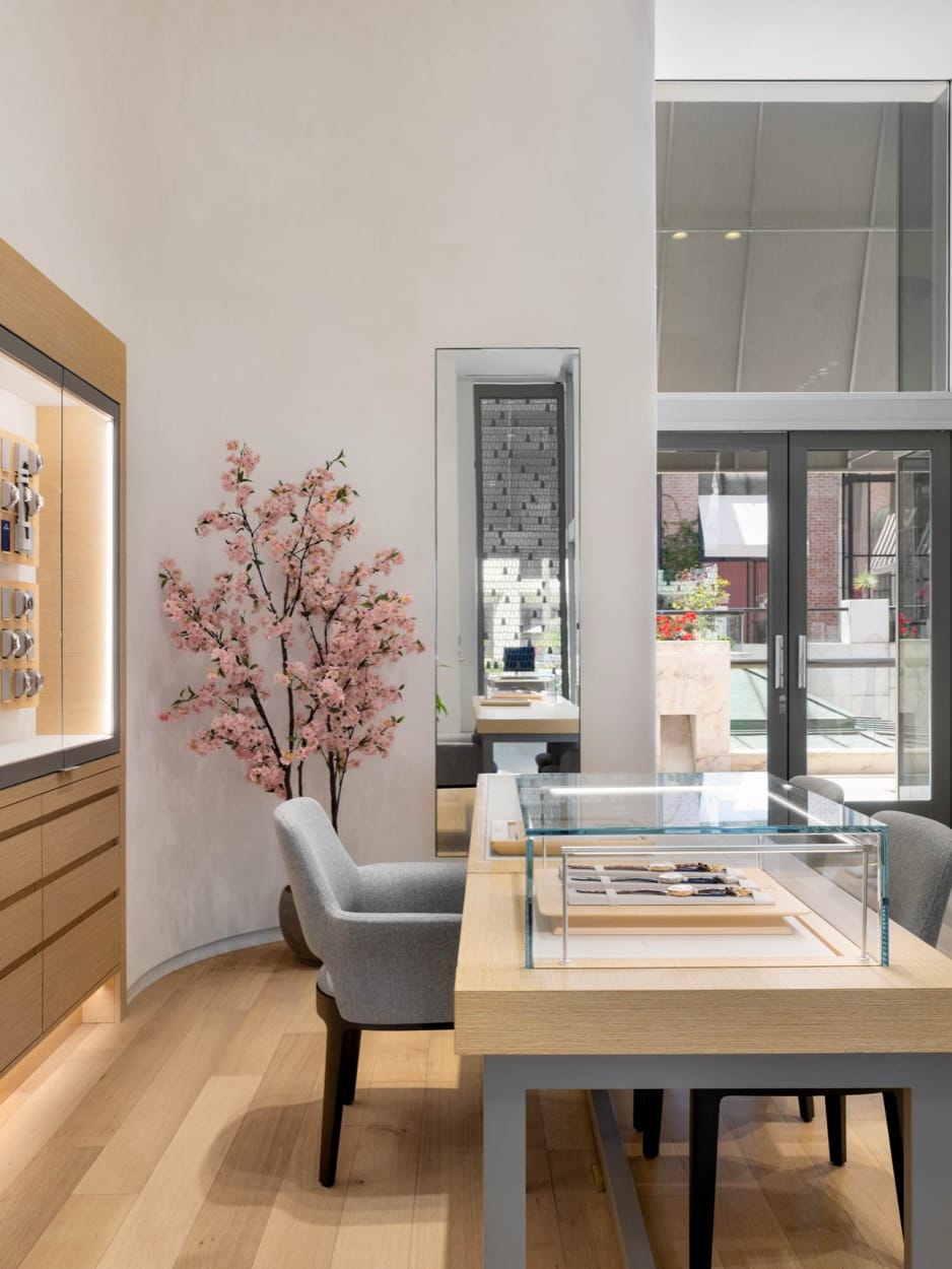 Grand Seiko desk beside a blossom branch, the street through the windows