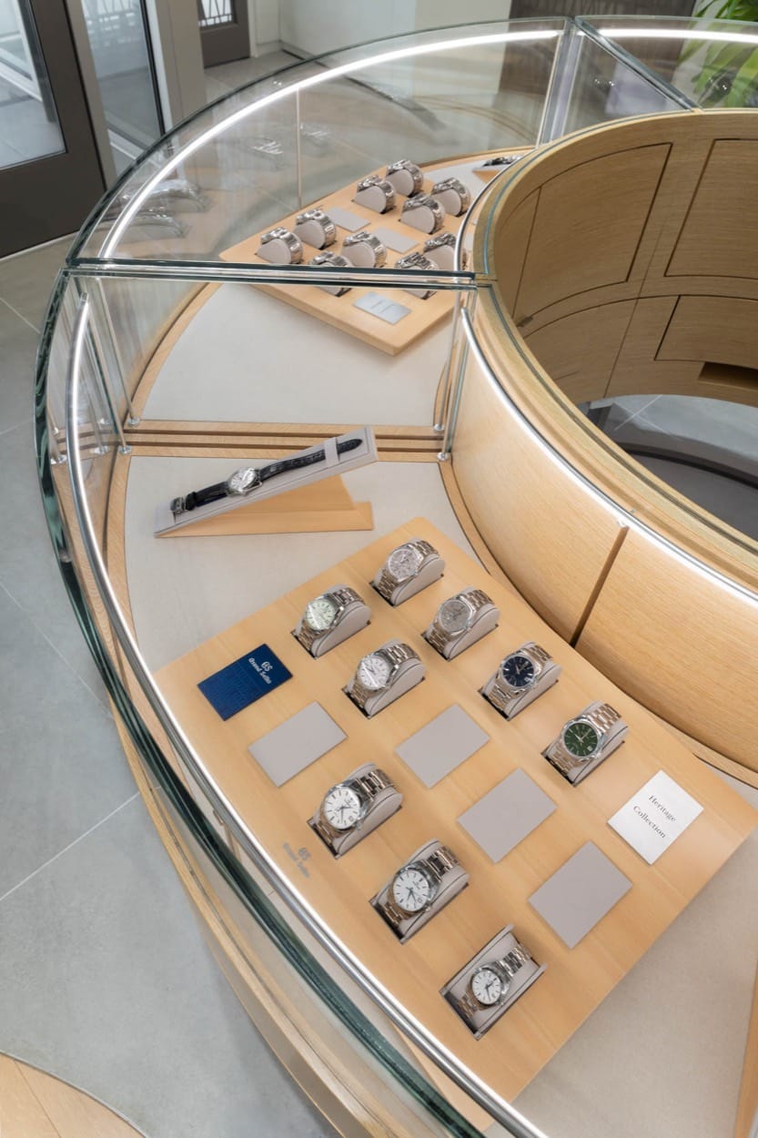 Grand Seiko watches in a curved glass display case, from above