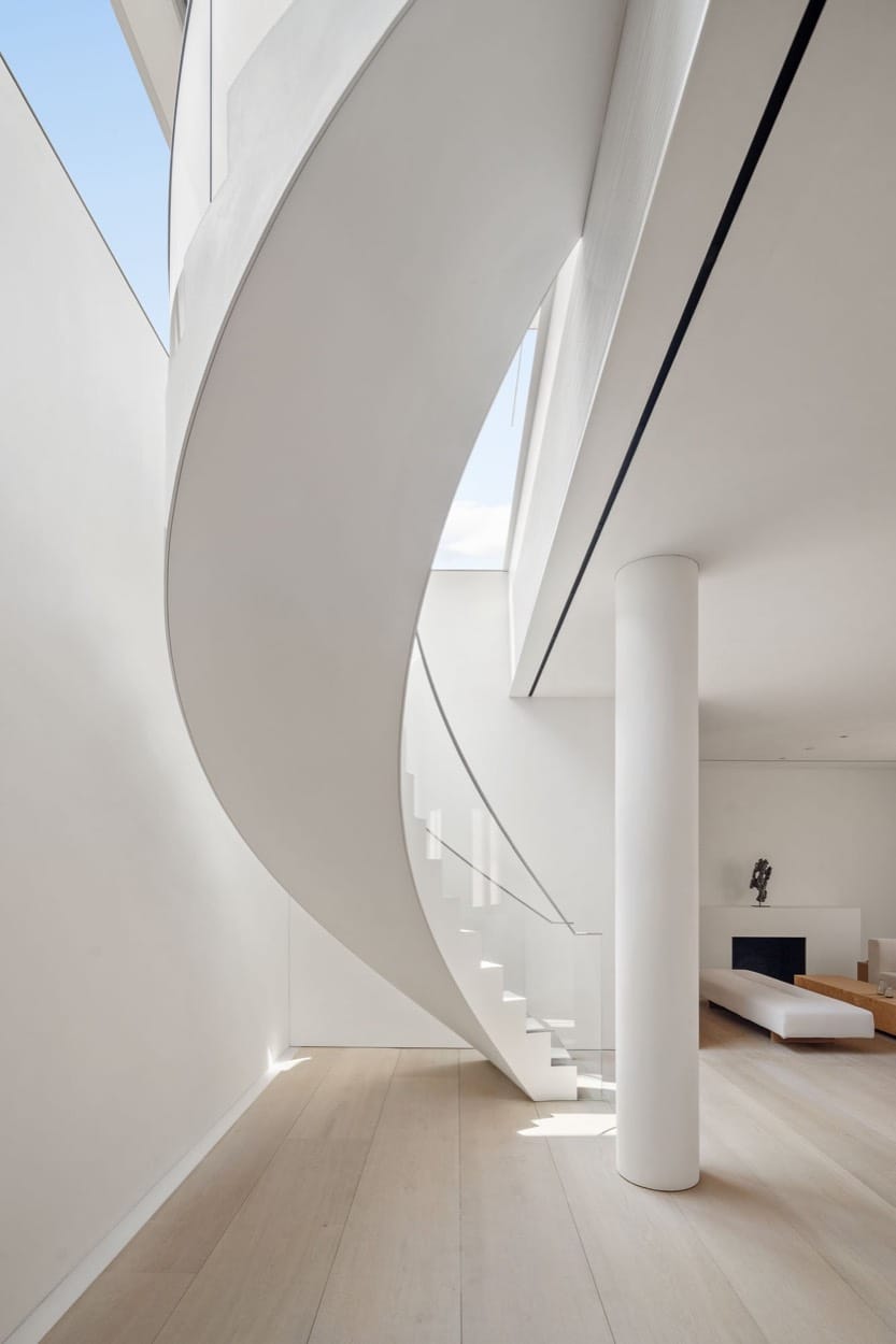 Escalera de caracol blanca en una casa minimalista, pisos de roble claro
