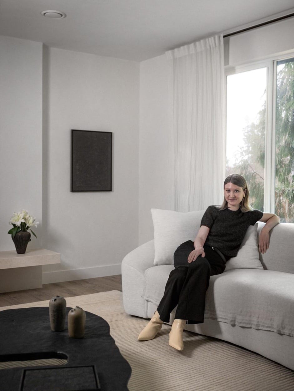 Jane Kidder on a curved white sofa in a bright minimalist living room