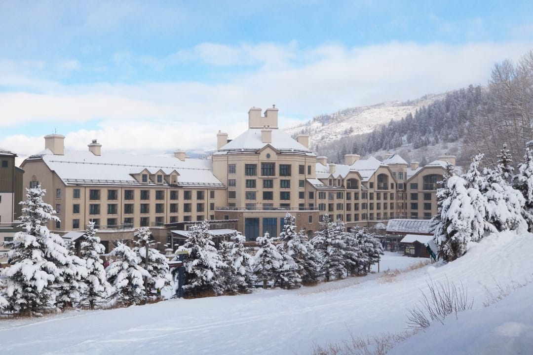 Park Hyatt Beaver Creek bajo nieve fresca, con pinos cargados de nieve al frente