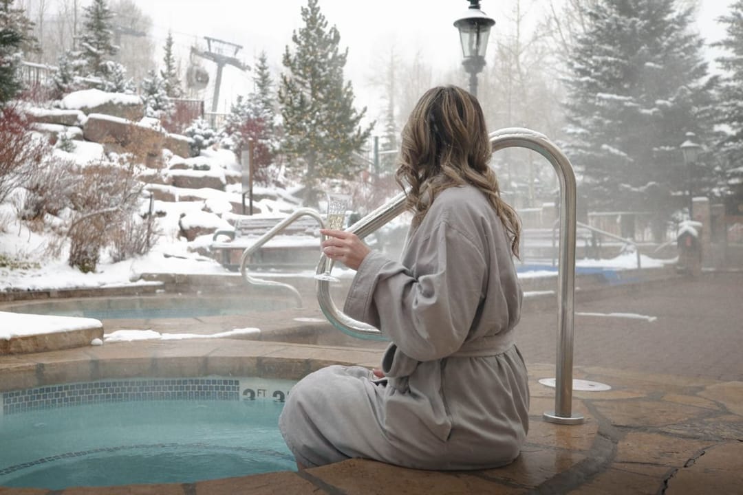 Huésped en bata junto al jacuzzi exterior mientras cae la nieve, Park Hyatt Beaver Creek