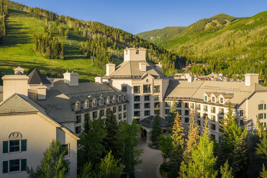 Park Hyatt Beaver Creek among pines below green summer ski runs