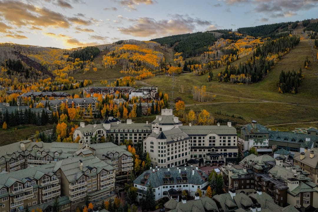Park Hyatt Beaver Creek y el pueblo desde el aire en otoño, con álamos dorados en las laderas