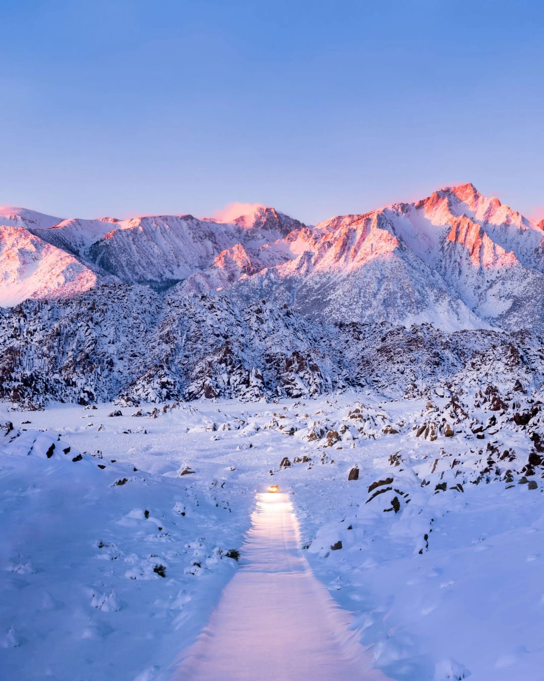 Winter Road. Un camino nevado hacia picos teñidos de rosa